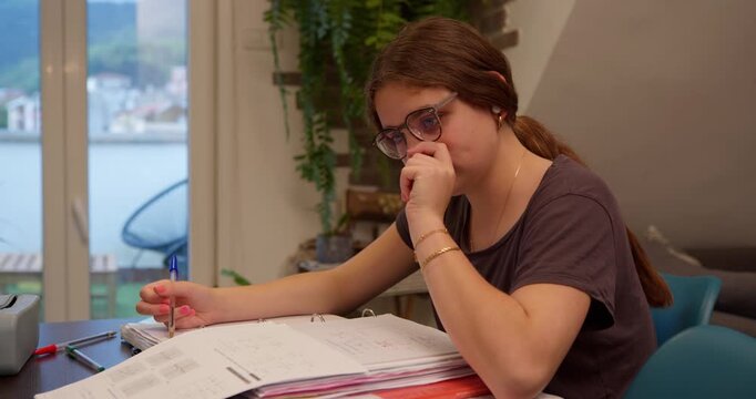 Focused Study: A young woman diligently engrossed in academic pursuits, studying with deep concentration, indoors in a well-lit study area.