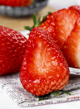 Fresh Cut Strawberries Still Life Studio Food Photography with Juicy Red Interior on Kitchen Towel
