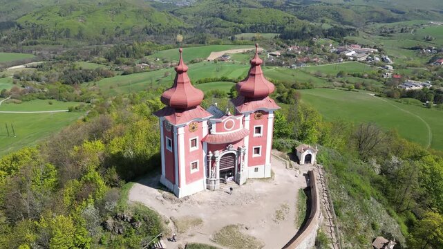 Aerial drone view orbiting the baroque Kalvaria Church complex. Famous religious monument sitting on a hill above Banska Stiavnica, Slovakia