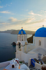 Obraz premium traditional greek village Oia of Santorini, with blue domes of churches at sunset, Greece, retro toned