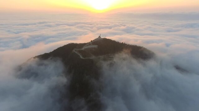 Aerial mosque and minaret above cloud ocean at sunrise during Ramadan, serene prayer scene. Islamic shrine, misty ridge, dawn glow, spiritual worship, tranquil Sufi sanctuary, stock search wording.