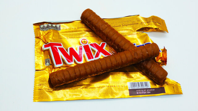 Twix candy bars placed on an open wrapper on a white surface during daytime