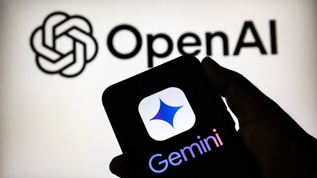 Closeup of a hand holding a smartphone displaying the google gemini logo in front of a blurred openai logo on a screen, representing ai competition