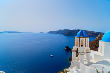 traditional greek village Oia of Santorini, with blue domes and white walls against sea and caldera, Greece © neirfy