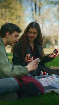 High school friends are learning about anatomy by examining a heart model in a park. These students are enjoying an educational discussion and discovery session outdoors.