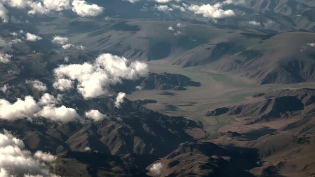 Treeless hills and rugged mountains in Potosi Oruro Bolivia beneath broken cloud cover. Barren slopes, rocky highland ridges, Altiplano valleys reveal remote dry earth textures.