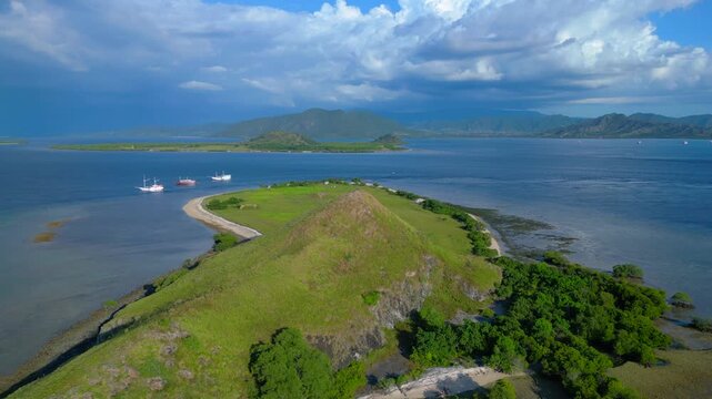 Hiking hill in national park landscape, phinisi boats. Lovely aerial view drone