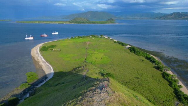 Hiking hill in national park landscape, phinisi boats. Nice aerial view drone