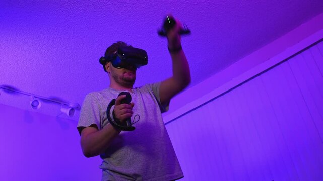 Man wearing virtual reality headset looking down controlling virtual space interacting with digital environment and immersing into modern gaming technology experience