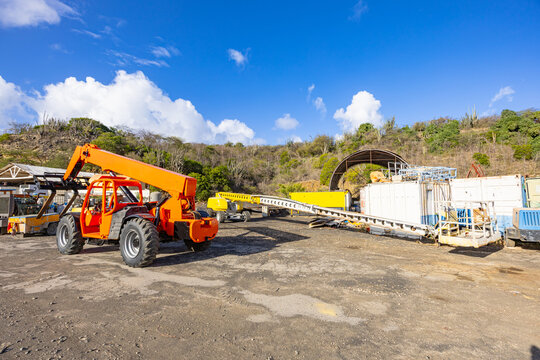 Orange telescopic handler and industrial machinery at a construction site or rental yard in Willemstad Curacao