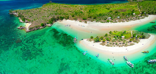 Drone shot of Pink Beach Lombok Indonesia highlighting unique pink sand cliffs turquoise ocean and tropical vegetation © jovannig