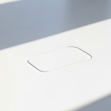 Minimalist white flush mounted touch sensor button on clean architectural surface design.