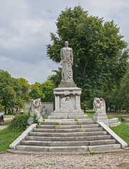 Fototapeta premium grave monument with statue of a men with a sword and grieving woman and angels in Kerepesi, historical graveyard along Fiume Road in Budapest, Hungary