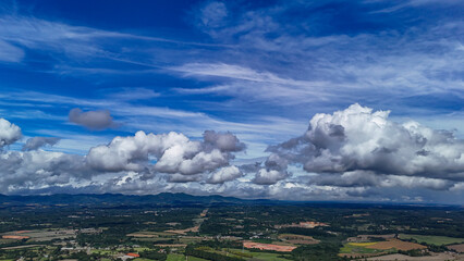 A wide-angle composition that highlights the contrast between a dynamic, cloud-laden sky and the vast, varied vegetation at its base. © Roberto