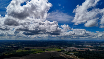 A wide-angle composition that highlights the contrast between a dynamic, cloud-laden sky and the vast, varied vegetation at its base. © Roberto