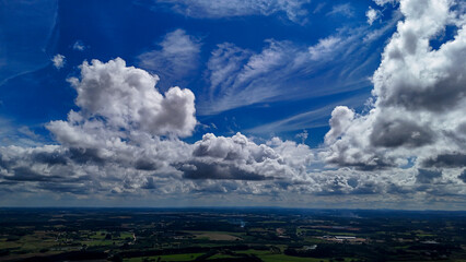 A wide-angle composition that highlights the contrast between a dynamic, cloud-laden sky and the vast, varied vegetation at its base. © Roberto