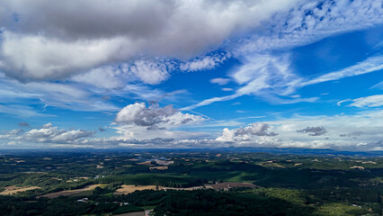 A wide-angle composition that highlights the contrast between a dynamic, cloud-laden sky and the vast, varied vegetation at its base. © Roberto
