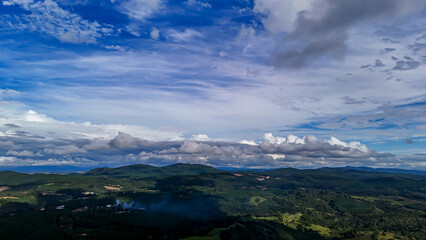 A wide-angle composition that highlights the contrast between a dynamic, cloud-laden sky and the vast, varied vegetation at its base. © Roberto