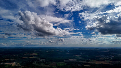 A wide-angle composition that highlights the contrast between a dynamic, cloud-laden sky and the vast, varied vegetation at its base. © Roberto
