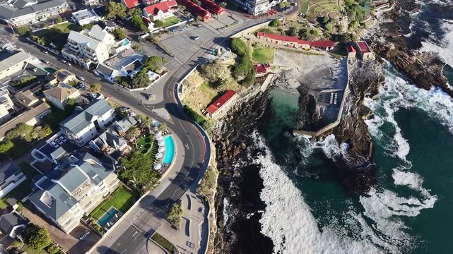 Hermanus, South Africa - January 19, 2026: Aerial drone view of Hermanus from the ocean, waves rolling along the coastline, clear blue sky and scenic seaside town in South Africa.