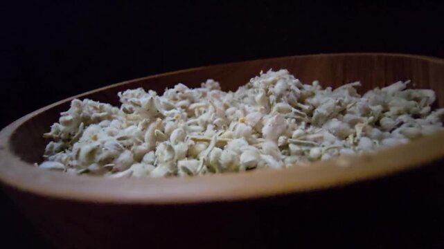 Macro shot of dried Teucrium polium (Felty Germander), a medicinal mountain herb from the Saudi desert used in folk medicine and blood sugar regulation, served in a wooden bowl.