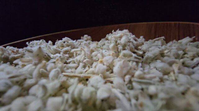 Macro shot of dried Teucrium polium (Felty Germander), a medicinal mountain herb from the Saudi desert used in folk medicine and blood sugar regulation, served in a wooden bowl.
