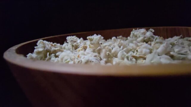 Macro shot of dried Teucrium polium (Felty Germander), a medicinal mountain herb from the Saudi desert used in folk medicine and blood sugar regulation, served in a wooden bowl.