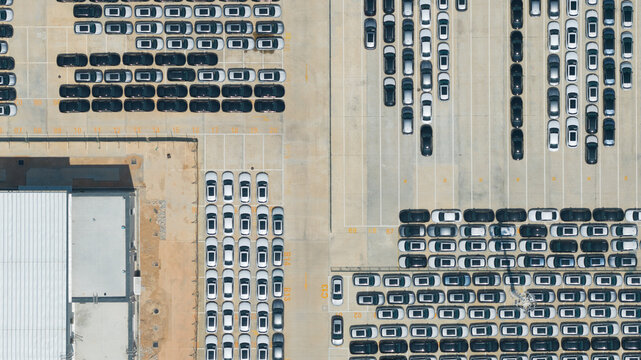 Aerial view of the BYD Thailand Rayong Office Building and rows of new electric vehicles parked in a large logistics lot Phananikhom, Rayong, Thailand.