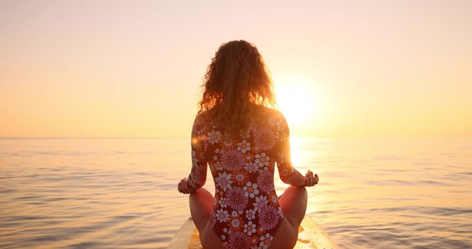 Happy young woman walking on a sup board by the sea during her summer vacation. Slow motion