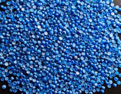close up flat lay of a blue plastic polypropylene granules on a table copy space