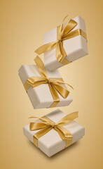 Fototapeta premium Floating beige gift boxes with gold satin ribbons and bows.