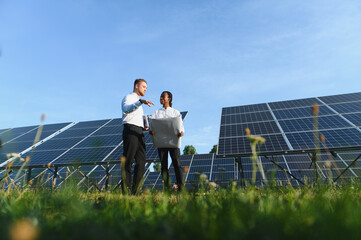 Engineers discussing solar energy project at solar farm © Serhii
