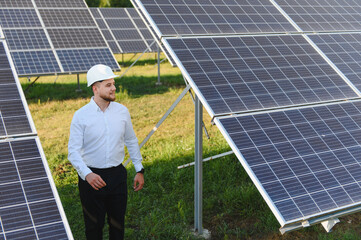 Fototapeta premium Engineer inspecting solar panels at photovoltaic power plant