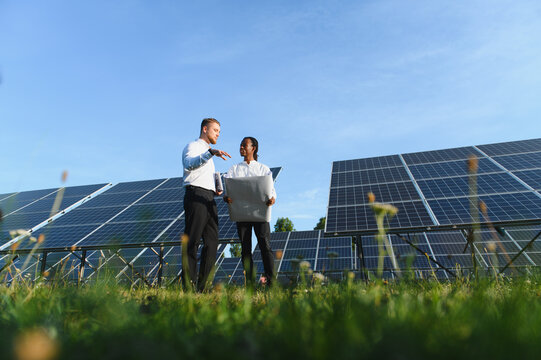 Engineers discussing solar energy project at solar farm
