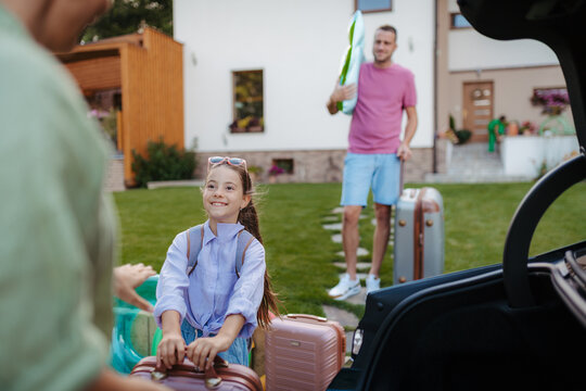 Family loading car and preparing for summer vacation.