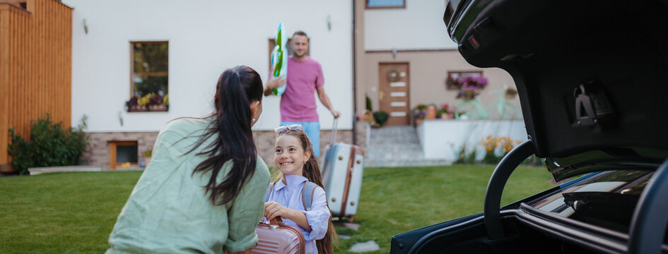 Family loading car and preparing for summer vacation.