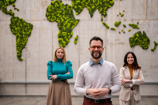 Global business team standing in front of world map