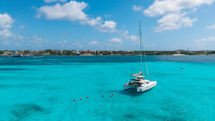 Obraz premium Catamaran Anchored with Snorkelers on Turquoise Caribbean Sea with Dramatic Clouds, Mexico