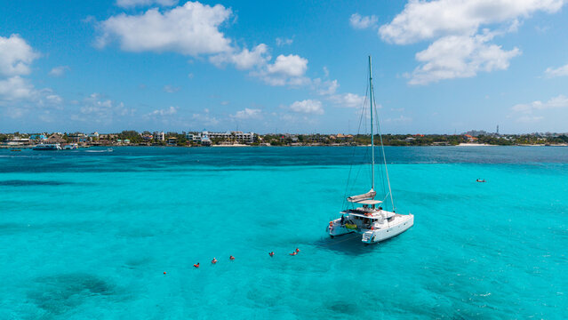 Catamaran Anchored with Snorkelers on Turquoise Caribbean Sea with Dramatic Clouds, Mexico