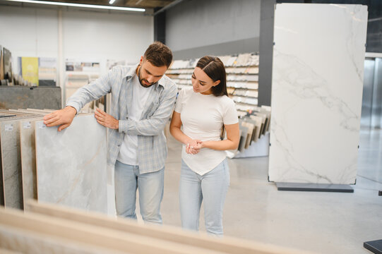 Couple choosing floor tiles in home improvement store