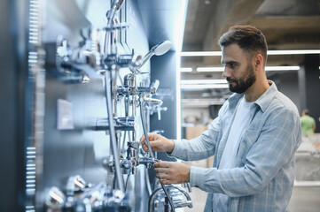 Obraz premium Man choosing shower system in plumbing store