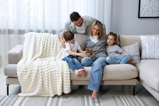 Happy family with their cute cat at home. Adorable pet