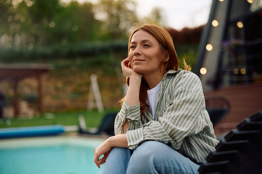Carefree woman enjoying in spring day while relaxing in backyard.