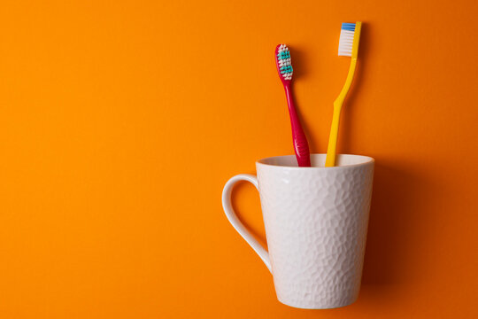 Minimalist Composition Featuring Toothbrushes And Toothpaste In Clean Studio Setting With Vibrant Colors