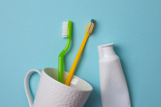 Minimalist Composition Featuring Toothbrushes And Toothpaste In Clean Studio Setting With Vibrant Colors