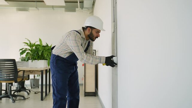 Professional electrician installing a light switch
