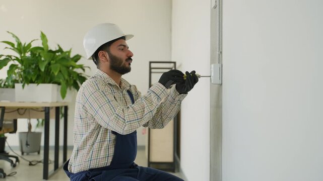 Professional electrician installing a wall light switch