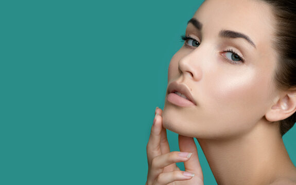 Portrait of beauty model with make-up, formed eyebrows  and long eyelashes. Beautiful young smiling women face with perfect fresh skin. Spa, skincare and wellness. Selective focus. Close-up