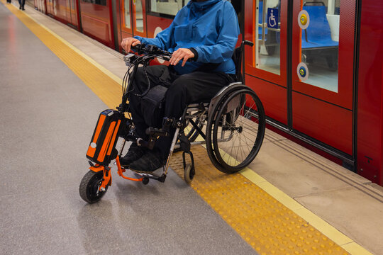 Person with disability on wheelchair using metro station for accessible transport.