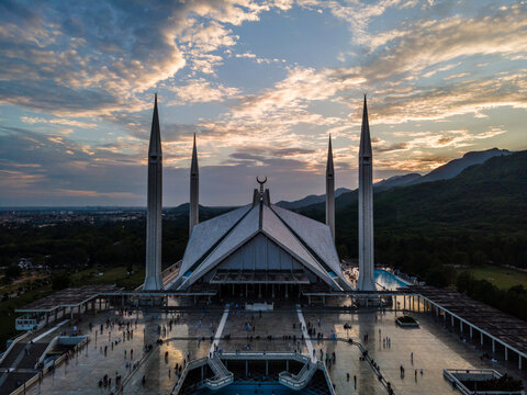 Aerial view of Faisal Masjid with its iconic four minarets and tent-shaped architecture under a sunset sky with the Margalla Hills in the background Islamabad, Islamabad Capital Ter, Pakistan.